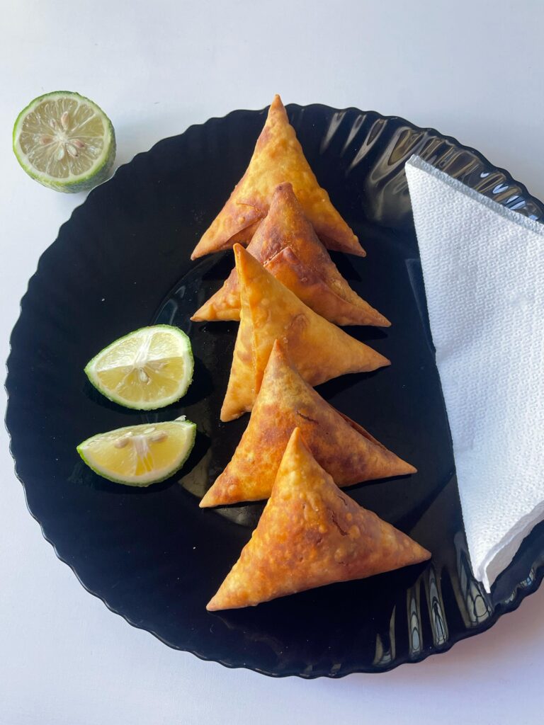 Fried samosas served with lime